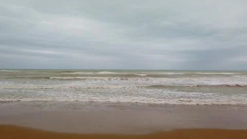 Overcast seashore showing waves rolling onto sandy beach Video stock 342019349