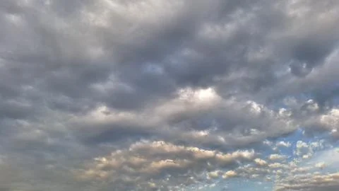 Overcast sky with grey storm clouds and sunset light Stock Photos