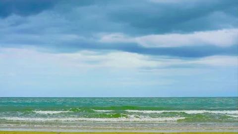 Overcast Sky with Ocean Waves Rolling Onto Beach Shore in Calm Seascape Stock Footage 338216030