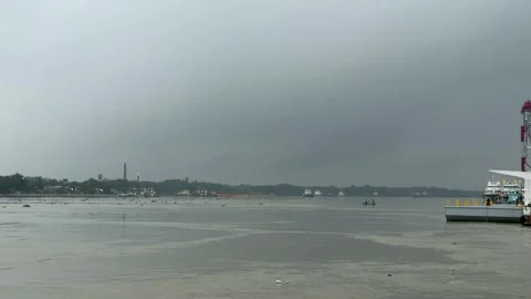 Overcast sky over a calm river with distant shoreline and industrial struct.. Video stock 340221576