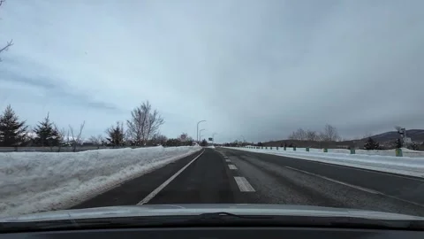 Overcast snowy highway with lane split and exit signs Stock Footage 333230058
