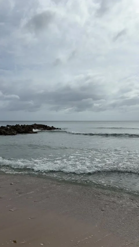 Overcast Waves Rolling onto Sandy Caribbean Beach, Barbados Stockbeeldmateriaal 338410974