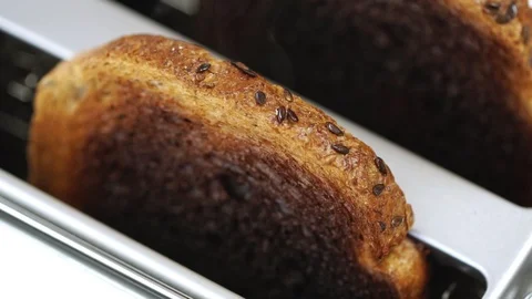 Overcooked and burnt toast bread smoking in white toaster machine 動画素材 87815126