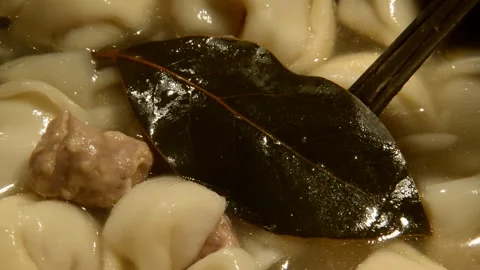 Overcooked dumplings ravioli with bay leaf and black pepper Stock Footage 291556217