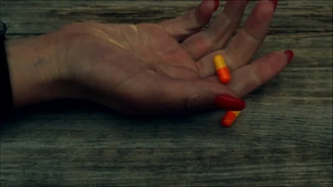 Overdose -  of pills in hand addict lying on the floor Stockbeeldmateriaal 90896824