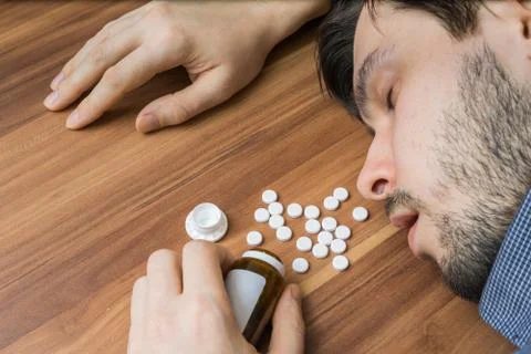 Overdose of pills. Man is lying on table. Foto stock