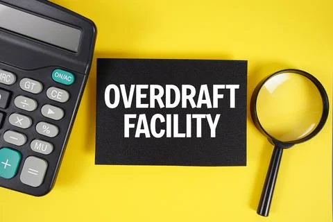 Overdraft Facility text with magnifying glass anc calculator on yellow back.. Stock Photos
