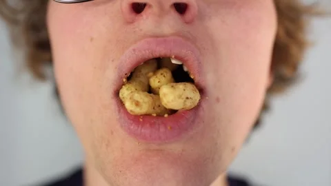 Overeating unhealthy snacks with missing front teeth in an extreme closeup showi Stock Footage 312203026