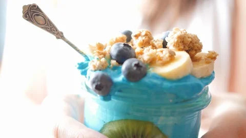 Overexposed, hands holding blue majik, spirulina smoothie, showing, giving Stock Footage 87828215