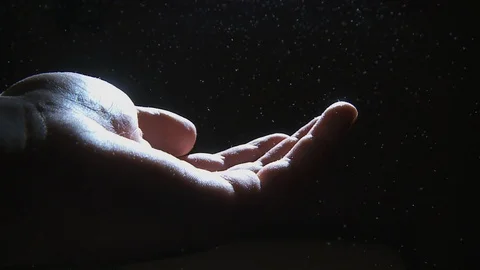 Overexposed Human Hand Extended in Space Surrounded by Floating Particles in Air Vídeo Stock 86617515