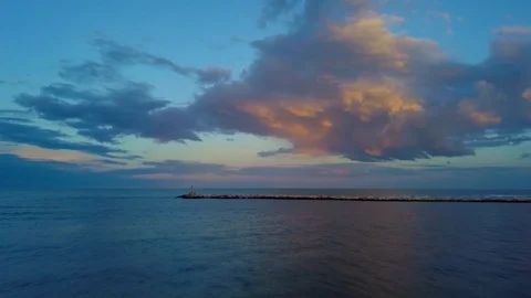 Overflight on the sea at sunset with a dike in front and a beautiful sky Vidéo 88323222