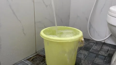 Overflow water on yellow plastic bucket at bathroom Stock Footage 312389331