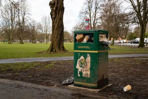 An overflowing bin in a park Stock Photos