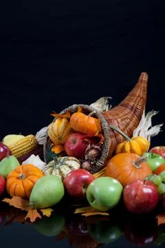 An overflowing cornucopia on a black background Stock Photos