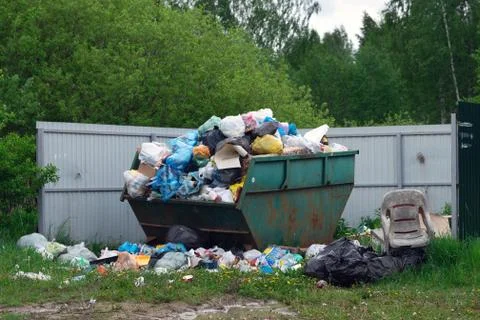 Overflowing dumpster at russian countryside in summer Stock Photos