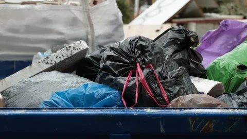 Overflowing Garbage Bin with Plastic Bags Swaying in the Wind Stock Footage 328382695