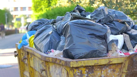 Overflowing garbage container on the street in 4k slow motion 60fps Stock Footage 233251508