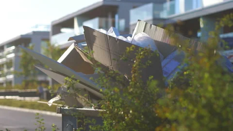 Overflowing garbage container on the street in 4k slow motion 60fps Stock Footage 233265363