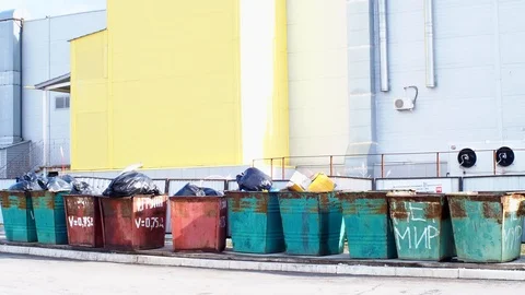 Overflowing garbage containers with garbage near an industrial building Stock Footage 125895007