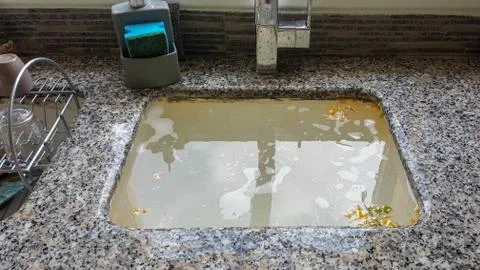 Overflowing kitchen sink, clogged drain. Stock Photos