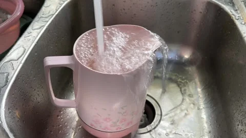 Overflowing Pink Mug in Kitchen Sink Stock Footage 325409959