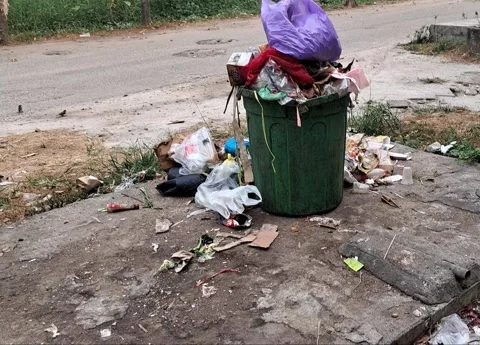 Overflowing Public Trash Bin with Scattered Garbage Stockbeeldmateriaal 345043778
