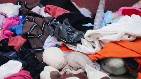 Overflowing trash bins with clothes, piles of unwanted clothes lying, clothing Stock Footage 326433997