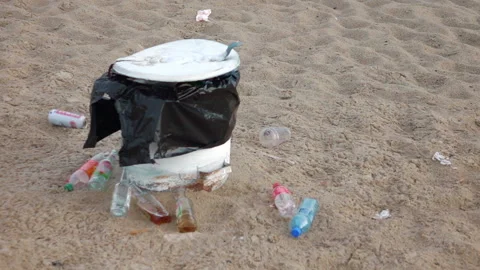 Overflowing trash can on the beach in slow motion 250fps Stock Footage 152718702