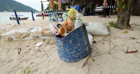Overflowing trash can with disposable plates and cups at Perhentian beach Stock Footage 314635981