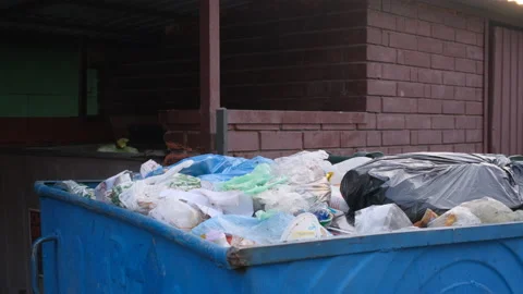 Overflowing trash can. Lots of garbage in urban street scene. Container with Stock Footage 168672877