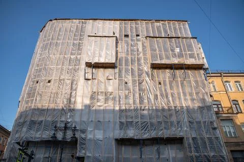 Overhaul of building facade, protective frame on house against dust and Stock Photos
