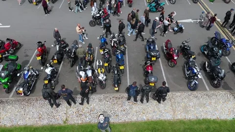 Overhead aerial drone tracking right shot of parked motorcycles and crowds Stock Footage 335313989