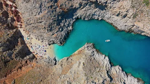Overhead aerial drone view of a vivid turquoise cove with a small sandy beach Stock Footage 339293681
