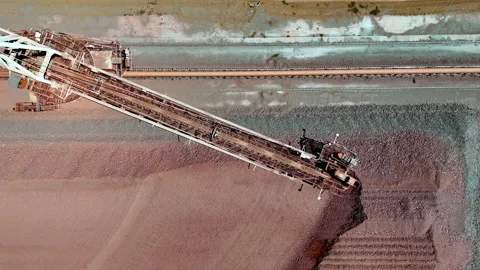Overhead aerial over mining conveyor system scooping up mined iron ore Stock Footage 333372444