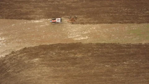 Overhead aerial shot of a tractor working in the field at daytime Stock Footage 142199372
