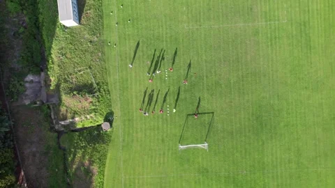 Overhead aerial of soccer team doing drills at practice, cool evening shadows 库存影片 336700296