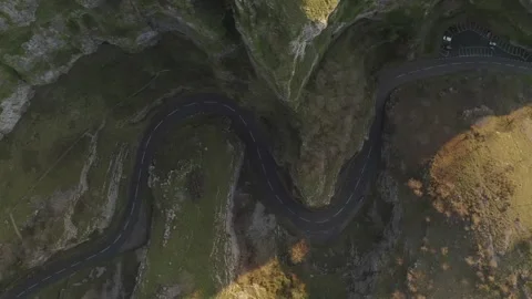 Overhead aerial tracking along empty bendy road winding through Cheddar Gorge Stock Footage 250791166