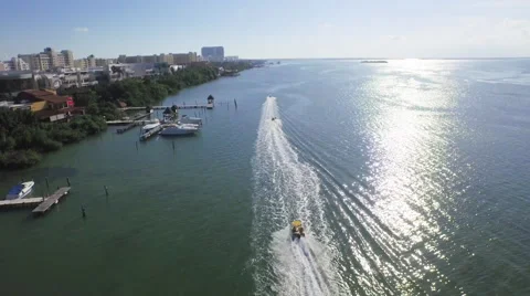 Overhead aerial tracking shot as fun recreational speed boat motors by lagoon Video stock 63305594