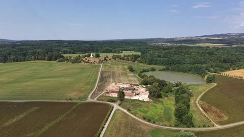 Overhead aerial view of patchwork farmland with winding road, rustic farmstead Stock Footage 348504242