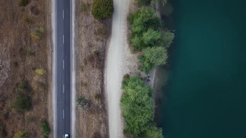 An overhead aerial view shows an empty asphalt highway running parallel to a Stock Footage 345619891