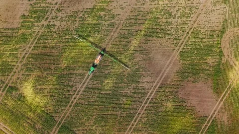 Overhead Aerial view of a tractor spraying a dry and parched agricultural field Video stock 315213453