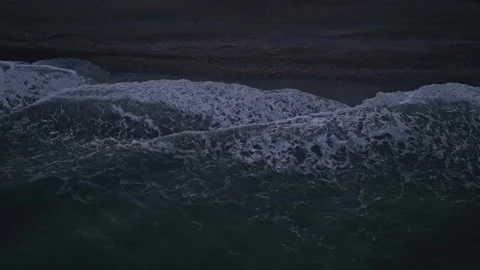 Overhead Aerial View of Waves Crashing on Dark Sand Beach at Dusk Stock Footage 342470651