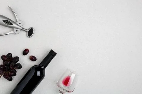 Overhead angled view of a large bottle of red wine, drinking glass on white Stock Photos