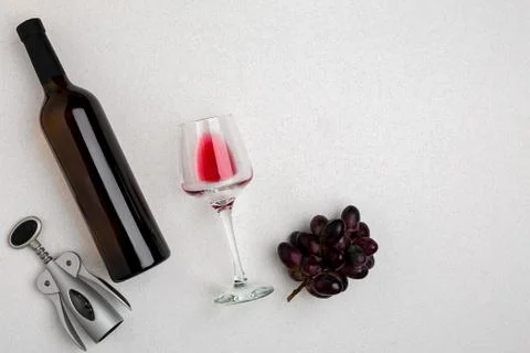 Overhead angled view of a large bottle of red wine, drinking glass on white Stock Photos