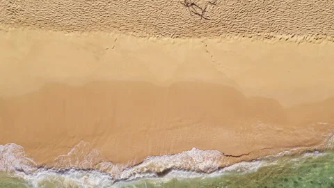 Overhead blue green waves breaking on golden sand beach 02  2.7k 60fps Stock Footage 155780317