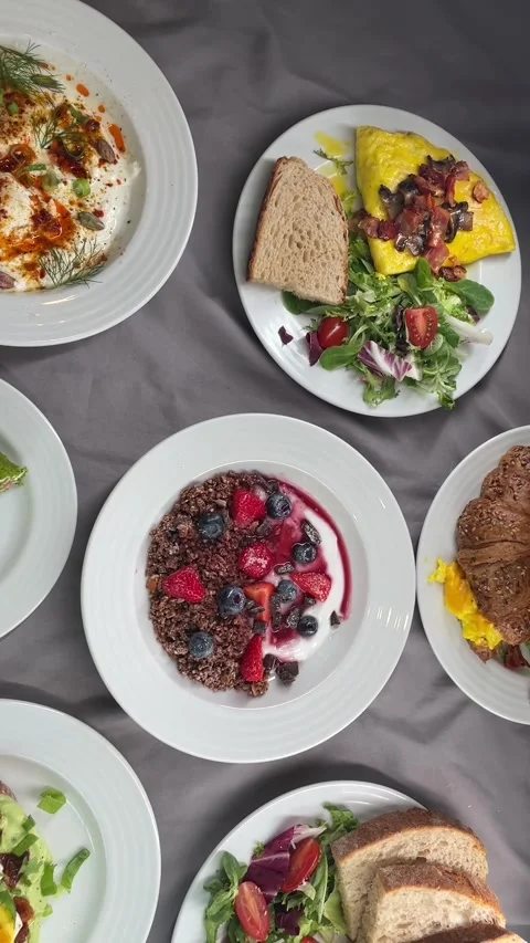 Overhead brunch spread with granola yogurt bowl, omelet, berries and bread berry Stock Footage 341626219