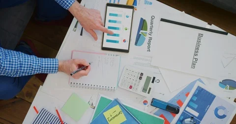 Overhead Of Businessman Using Digital Tablet While Preparing Financial Report 4K Stock Footage 92370173