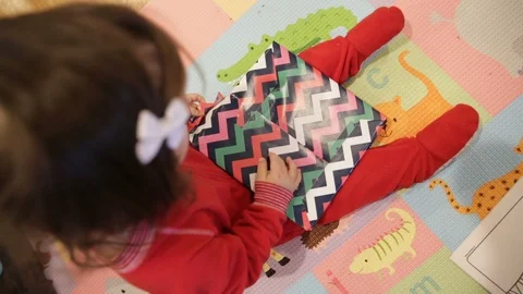 Overhead of Child Opening Up a Wrapped Gift Stock Footage 94084673