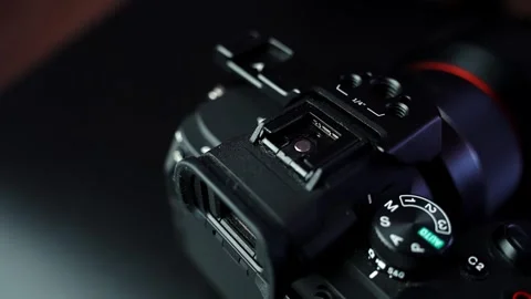 Overhead close-up of mirrorless camera top plate with hot shoe and mode dial in Stock Footage 328974816