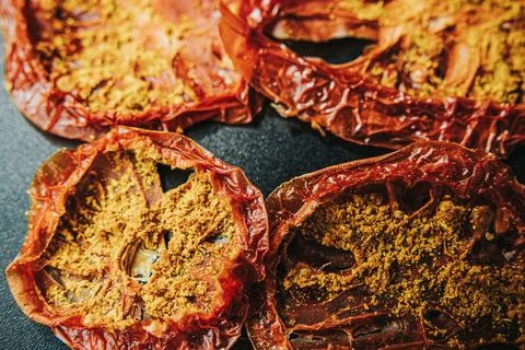 Overhead close-up of multiple sun-dried tomato slices coated. Stock Photos
